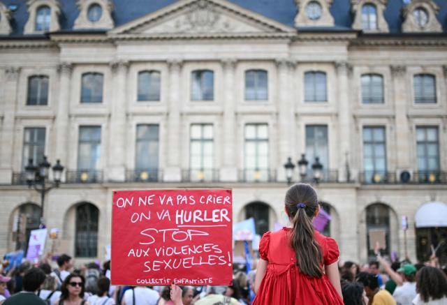 A protestor holds a placard reading "We won't just shout; we'll scream. Stop sexual violence" during a demonstration at Place Vendome outside the French Justice Ministry in Paris on June 29, 2026 to demand a law against violence on minors, following the death of Lyhanna. For the fourth consecutive Monday since Lyhanna's death, protests are continuing across France—called by a coalition advocating for women's and children's rights—to demand comprehensive legislation against sexual violence. Lyhanna, 11, who went missing in France, was raped before she died and anger grew after it emerged that the main suspect, the 41-year-old father of a school friend, had twice before been formally accused of raping a child but the investigations had been dropped or had stalled. (Photo by Julie SEBADELHA / AFP)