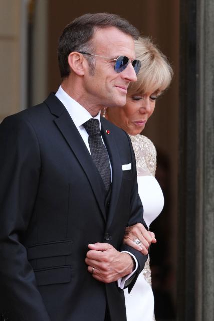 France's President Emmanuel Macron (L) and his wife Brigitte Macron (R) wait to greet Thailand's King Maha Vajiralongkorn on the steps of The Elysee Presidential Palace ahead of a working dinner as part of the Thai King's State visit to France, in Paris on June 29, 2026. (Photo by Dimitar DILKOFF / AFP)