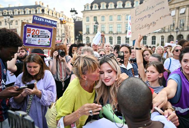 A protestor embraces a victim of sexual violences after her speech during a demonstration at Place Vendome outside the French Justice Ministry in Paris on June 29, 2026 to demand a law against violence on minors, following the death of Lyhanna. For the fourth consecutive Monday since Lyhanna's death, protests are continuing across France—called by a coalition advocating for women's and children's rights—to demand comprehensive legislation against sexual violence. Lyhanna, 11, who went missing in France, was raped before she died and anger grew after it emerged that the main suspect, the 41-year-old father of a school friend, had twice before been formally accused of raping a child but the investigations had been dropped or had stalled. (Photo by Julie SEBADELHA / AFP)