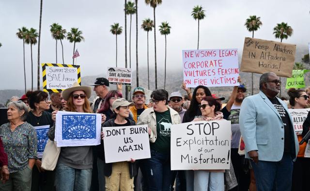 Survivors of the 2025 Eaton Fire hold signs during a demonstration in Altadena, California, on June 29, 2026. Altadena residents are expressing support of California Senate Bill SB 1090, which addresses disaster recovery, restricting rapid large-scale investor purchases and exemptions in fire-damaged areas from dense housing laws, allowing for local residents to rebuild without having coprporate buyers displace them. (Photo by Frederic J. BROWN / AFP)