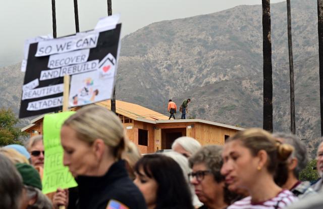 As a new house is under construction, survivors of the 2025 Eaton Fire participate in a demonstration in Altadena, California, on June 29, 2026. Altadena residents are expressing support of California Senate Bill SB 1090, which addresses disaster recovery, restricting rapid large-scale investor purchases and exemptions in fire-damaged areas from dense housing laws, allowing for local residents to rebuild without having coprporate buyers displace them. (Photo by Frederic J. BROWN / AFP)