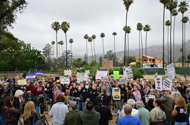 The Chair of the Altadena Town Council Nic Arnzen (C) speaks during a gathering of survivors of the 2025 Eaton Fire in Altadena, California, on June 29, 2026. Altadena residents are expressing support of California Senate Bill SB 1090, which addresses disaster recovery, restricting rapid large-scale investor purchases and exemptions in fire-damaged areas from dense housing laws, allowing for local residents to rebuild without having coprporate buyers displace them. (Photo by Frederic J. BROWN / AFP)