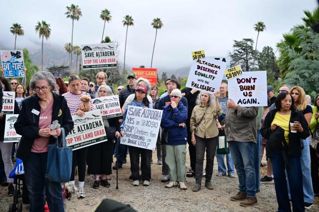 Survivors of the 2025 Eaton Fire hold signs during a demonstration in Altadena, California, on June 29, 2026. Altadena residents are expressing support of California Senate Bill SB 1090, which addresses disaster recovery, restricting rapid large-scale investor purchases and exemptions in fire-damaged areas from dense housing laws, allowing for local residents to rebuild without having coprporate buyers displace them. (Photo by Frederic J. BROWN / AFP)