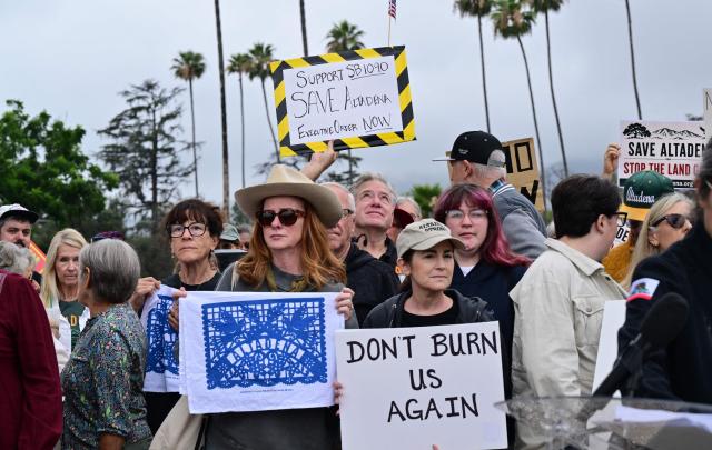 Survivors of the 2025 Eaton Fire hold signs during a demonstration in Altadena, California, on June 29, 2026. Altadena residents are expressing support of California Senate Bill SB 1090, which addresses disaster recovery, restricting rapid large-scale investor purchases and exemptions in fire-damaged areas from dense housing laws, allowing for local residents to rebuild without having coprporate buyers displace them. (Photo by Frederic J. BROWN / AFP)