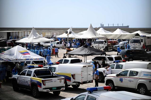 EDITORS NOTE: Graphic content / Forensic personnel and emergency workers gather under tents during body identification operations at a makeshift morgue in the port of La Guaira, La Guaira State, Venezuela on June 29, 2026, days after twin earthquakes struck the country. Hopes were fading on June 29, 2026 of finding survivors more than four days after powerful twin earthquakes struck Venezuela, as residents grow increasingly frustrated with the government's response to the disaster that has killed at least 1,450 people and left tens of thousands unaccounted for. (Photo by Federico PARRA / AFP)