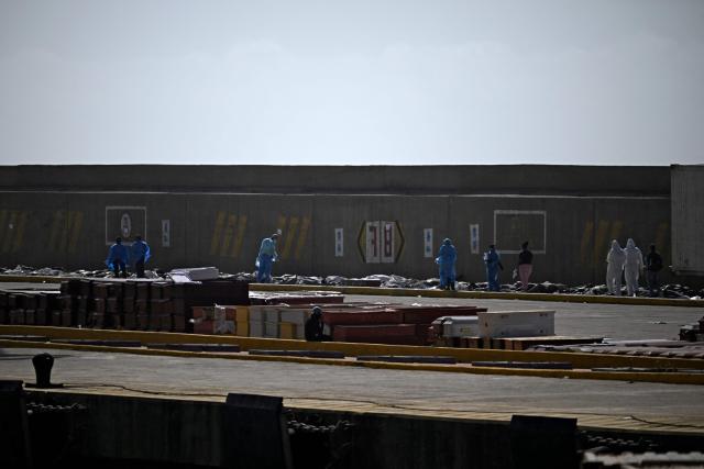 EDITORS NOTE: Graphic content / Forensic experts carry out body identification work on corpses laid out on the ground at a makeshift morgue in the port of La Guaira, La Guaira State, Venezuela on June 29, 2026, days after twin earthquakes struck the country. Hopes were fading on June 29, 2026 of finding survivors more than four days after powerful twin earthquakes struck Venezuela, as residents grow increasingly frustrated with the government's response to the disaster that has killed at least 1,450 people and left tens of thousands unaccounted for. (Photo by Federico PARRA / AFP)