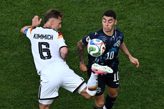 Germany's defender #06 Joshua Kimmich controls the ball past Paraguay's midfielder #10 Miguel Almiron during the 2026 World Cup round of 32 football match between Germany and Paraguay at the Boston Stadium in Foxborough on June 29, 2026.  (Photo by Jewel SAMAD / AFP)