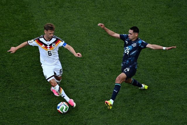 Germany's defender #06 Joshua Kimmich runs with the ball past Paraguay's forward #24 Gustavo Caballero during the 2026 World Cup round of 32 football match between Germany and Paraguay at the Boston Stadium in Foxborough on June 29, 2026.  (Photo by Jewel SAMAD / AFP)
