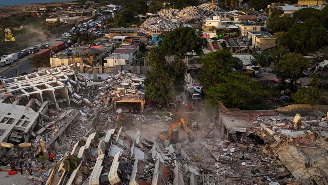 This aerial view shows buildings destroyed following twin earthquakes in Caraballeda, La Guaira State, Venezuela, on June 29, 2026. Volunteers and emergency brigades with rescue dogs continue lifting mountains of rubble in search of survivors of the twin earthquake that struck Venezuela four days ago, which completely brought down nearly 200 buildings and left at least 1,450 dead and tens of thousands missing. (Photo by Miguel MEDINA / AFP)