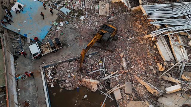 This aerial picture shows a backhoe loader working at the site of buildings destroyed during the June 24 twin earthquakes, in Caraballeda, La Guaira State, Venezuela, on June 29, 2026. Volunteers and emergency brigades with rescue dogs continue lifting mountains of rubble in search of survivors of the twin earthquake that struck Venezuela four days ago, which completely brought down nearly 200 buildings and left more than 1,700 dead and tens of thousands missing. (Photo by Miguel MEDINA / POOL / AFP)