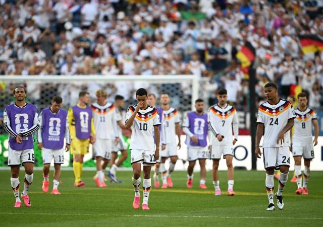 TOPSHOT - (From L) Germany's forward #19 Leroy Sane, midfielder #10 Jamal Musiala and defender #24 Malick Thiaw react after losing the penalty shootout during the 2026 World Cup round of 32 football match between Germany and Paraguay at the Boston Stadium in Foxborough on June 29, 2026.  (Photo by MAURO PIMENTEL / AFP)