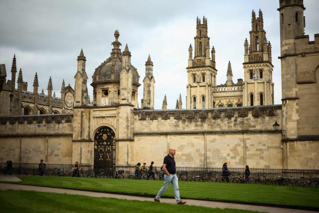 This photo taken on June 17, 2026 shows a man walking past the All Souls College Library at Oxford University in Oxford, central England. With its grand atrium, 500-seat acoustics-led concert hall and other state-of-the-art spaces, Oxford's Schwarzman Centre is the newest example of an elite UK university showcasing a billionaire's endowment. (Photo by HENRY NICHOLLS / AFP) / TO GO WITH Britain-education-universities-philanthrophy,FOCUS by Joe JACKSON