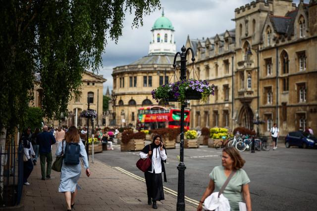This photo taken on June 17, 2026 shows a general view of pedestrians walking along Broad Street near Oxford University in Oxford, central England. With its grand atrium, 500-seat acoustics-led concert hall and other state-of-the-art spaces, Oxford's Schwarzman Centre is the newest example of an elite UK university showcasing a billionaire's endowment. (Photo by HENRY NICHOLLS / AFP) / TO GO WITH Britain-education-universities-philanthrophy,FOCUS by Joe JACKSON