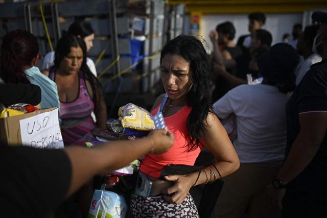Volunteers distribute medicines and basic supplies to residents affected by twin earthquakes in the Playa Verde sector of Catia La Mar, La Guaira state, Venezuela, on June 29, 2026. Hopes were fading of finding survivors more than four days after powerful twin earthquakes struck Venezuela, as residents grow increasingly frustrated with the government's response to the disaster that has killed -up to now- more than 1,700 people and left tens of thousands unaccounted for. (Photo by Federico PARRA / POOL / AFP)