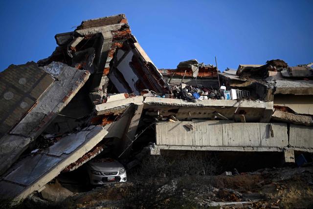 This view shows a collapsed concrete structure with crushed floors and debris, with a car partially buried beneath, in the Playa Verde sector of Catia La Mar, La Guaira state, Venezuela, on June 29, 2026, following twin earthquakes. Hopes were fading of finding survivors more than four days after powerful twin earthquakes struck Venezuela, as residents grow increasingly frustrated with the government's response to the disaster that has killed -up to now- more than 1,700 people and left tens of thousands unaccounted for. (Photo by Federico PARRA / POOL / AFP)