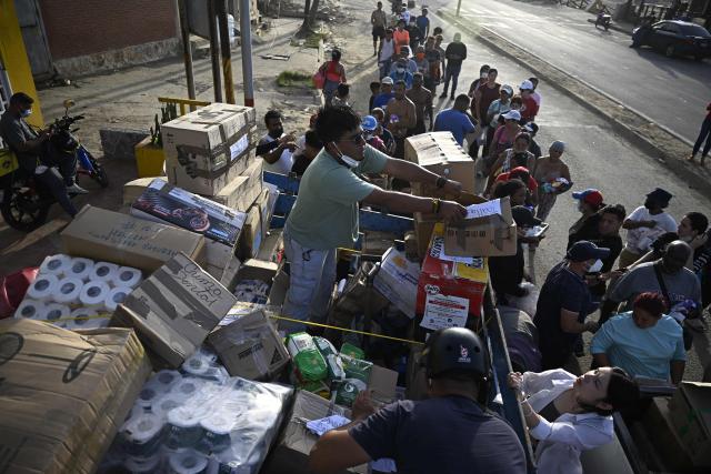 Volunteers distribute medicines and basic supplies to residents affected by twin earthquakes in the Playa Verde sector of Catia La Mar, La Guaira state, Venezuela, on June 29, 2026. Hopes were fading of finding survivors more than four days after powerful twin earthquakes struck Venezuela, as residents grow increasingly frustrated with the government's response to the disaster that has killed -up to now- more than 1,700 people and left tens of thousands unaccounted for. (Photo by Federico PARRA / POOL / AFP)