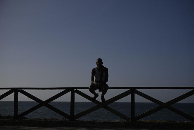 A man sits on a wooden seaside railing overlooking the sea in the Playa Verde sector of Catia La Mar, La Guaira state, Venezuela, on June 29, 2026, following twin earthquakes. Hopes were fading of finding survivors more than four days after powerful twin earthquakes struck Venezuela, as residents grow increasingly frustrated with the government's response to the disaster that has killed -up to now- more than 1,700 people and left tens of thousands unaccounted for. (Photo by Federico PARRA / POOL / AFP)