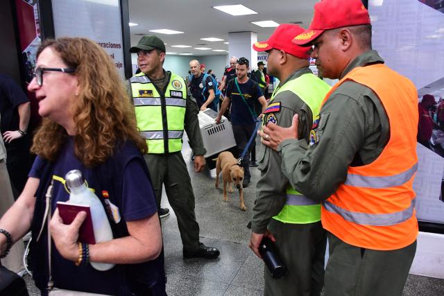 Members of Spain's volunteer association GEA Alicante, with a sniffer dog, walk upon arrive at Arturo Michelena International Airport in Valencia, Carabobo State, Venezuela, to assist in search operations following twin earthquakes, on June 29, 2026. Hopes were fading of finding survivors more than four days after powerful twin earthquakes struck Venezuela, as residents grow increasingly frustrated with the government's response to the disaster that has killed -up to now- more than 1,700 people and left tens of thousands unaccounted for. (Photo by Jacinto OLIVEROS / AFP)