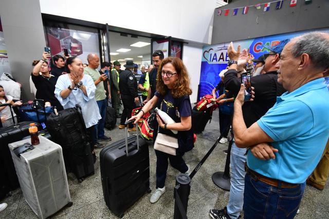 Passengers applaud as members of Spain's volunteer association GEA Alicante, leave Arturo Michelena International Airport upon arrival in Valencia, Carabobo State, Venezuela, to assist in search operations following twin earthquakes, on June 29, 2026. Hopes were fading of finding survivors more than four days after powerful twin earthquakes struck Venezuela, as residents grow increasingly frustrated with the government's response to the disaster that has killed -up to now- more than 1,700 people and left tens of thousands unaccounted for. (Photo by Jacinto OLIVEROS / AFP)