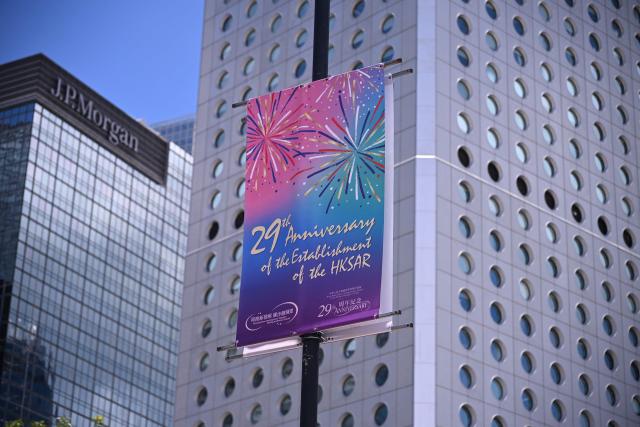 A banner marking the 29th anniversary of the handover of Hong Kong from Britain to China is seen on a street in Hong Kong on June 30, 2026. (Photo by Peter PARKS / AFP)