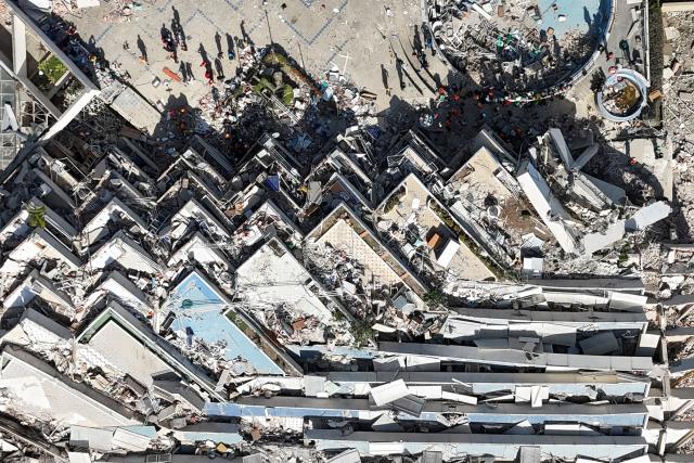 This aerial view shows a collapsed multi-storey building and surrounding debris near a coastal road following the June 24 twin earthquakes in Caraballeda, La Guaira State, Venezuela, on June 29, 2026. Hopes were fading of finding survivors more than four days after powerful twin earthquakes struck Venezuela, as residents grow increasingly frustrated with the government's response to the disaster that has killed -up to now- more than 1,700 people and left tens of thousands unaccounted for. (Photo by Yorman MALDONADO / AFP)