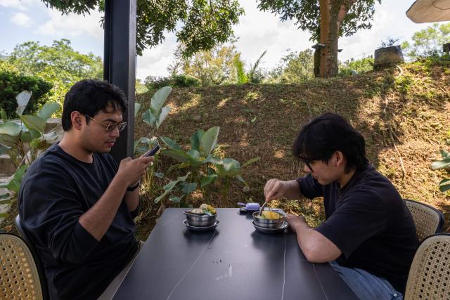 This photo taken on June 27, 2026 shows customers eating Musang King durian cendol dessert in Karak, in Malaysia's Pahang state. Found across Southeast Asia, the spiky fruit comes in many varieties and in Malaysia, the highly prized cultivar Musang King is consumed locally and exported, mainly to China. Malaysia, which produces more than 550,000 tonnes of durian a year, is currently in its peak harvest season. (Photo by Mohd Rasfan / AFP)