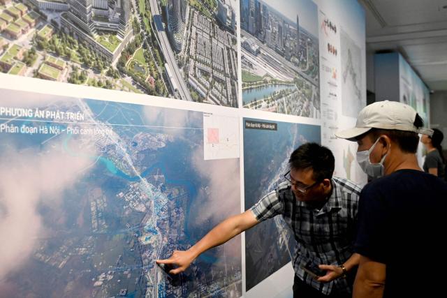 People looks at pictures at an exhibition for Hanoi's 100-year development master plan at the Hanoi Museum in Hanoi on June 30, 2026. (Photo by Nhac NGUYEN / AFP)