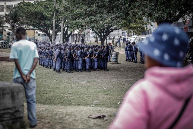 Members of the South African Police Service (SAPS) stand in formation as they receive instructions ahead of planned demonstrations by the March and March movement against the presence of undocumented migrants in South Africa in Durban, on June 30, 2026. South African police deployed to head off unrest and protests on June 30, 2026, the unofficial deadline set by citizen-led groups for undocumented foreign nationals to leave that has already pushed thousands to flee.
Officers were out in force to prevent violence and looting, while hundreds of foreign nationals took refuge in several cities, urgently seeking help to leave. (Photo by Marco LONGARI / AFP)