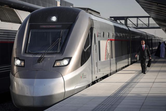An Etihad Rail employee walks towards the locomotive of the UAE's first passenger train on its inaugural journey at Mohamed bin Zayed City station in Abu Dhabi on June 30, 2026. The passenger service will eventually connect four of the country's seven emirates, with an "introductory operational phase" between Abu Dhabi and Fujairah to begin on June 30, state news agency WAM said earlier this month. The Dubai station will open on September 30, while the main station in the neighbouring emirate of Sharjah is set to be operational on March 30, 2027. (Photo by FADEL SENNA / AFP)