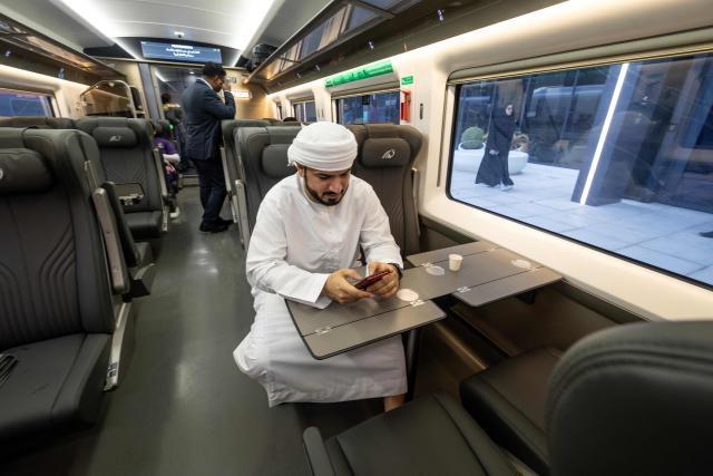A passenger sits in an Etihad Rail train, the UAE's first passenger train, on its inaugural journey at Mohamed bin Zayed City station in Abu Dhabi on June 30, 2026. The passenger service will eventually connect four of the country's seven emirates, with an "introductory operational phase" between Abu Dhabi and Fujairah to begin on June 30, state news agency WAM said earlier this month. The Dubai station will open on September 30, while the main station in the neighbouring emirate of Sharjah is set to be operational on March 30, 2027. (Photo by FADEL SENNA / AFP)