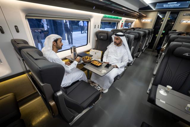 Passengers sit in an Etihad Rail train, the UAE's first passenger train, on its inaugural journey at Mohamed bin Zayed City station in Abu Dhabi on June 30, 2026. The passenger service will eventually connect four of the country's seven emirates, with an "introductory operational phase" between Abu Dhabi and Fujairah to begin on June 30, state news agency WAM said earlier this month. The Dubai station will open on September 30, while the main station in the neighbouring emirate of Sharjah is set to be operational on March 30, 2027. (Photo by FADEL SENNA / AFP)