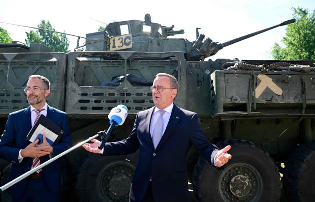 German Defence Minister Boris Pistorius (R) speaks to journalists in front of a General Dynamics combat infantry vehicle in Valka, Latvia, on the border with Estonia, during a NATO Change of Command ceremony on June 30, 2026 in Valka (Latvia) or Valga (Estonia). A joint German-Dutch army corps (1GNC) is taking command of NATO land forces in Latvia and Estonia. Officially transitioning on June 30, 2026, this move establishes a dedicated second corps headquarters on the eastern flank to speed up reinforcements and command combat operations in the Baltic region. (Photo by John MACDOUGALL / AFP)