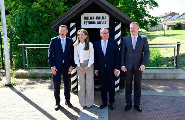 (L-R) Estonian Defence Minister Hanno Pevkur, Dutch Defence Minister Dilan Yesilgoz-Zegerius, German Defence Minister Boris Pistorius and Latvia's Defence Minister Raivis Melnis stand on the border crossing between Estonia (L) and Latvia (R) as they attend a NATO Change of Command ceremony on June 30, 2026 in Valka (Latvia) or Valga (Estonia). A joint German-Dutch army corps (1GNC) is taking command of NATO land forces in Latvia and Estonia. Officially transitioning on June 30, 2026, this move establishes a dedicated second corps headquarters on the eastern flank to speed up reinforcements and command combat operations in the Baltic region. (Photo by John MACDOUGALL / AFP)