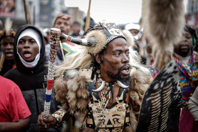 Members of the Zulu regiment known as the ‘Amabutho’ chant slogans as they march during a demonstration by the "March and March" movement marking an unofficial deadline set by citizen-led groups for undocumented foreign nationals to leave South Africa, in Durban, on June 30, 2026. South African police deployed to head off unrest and protests on June 30, 2026, the unofficial deadline set by anti-immigrant groups for undocumented foreign nationals to leave that has already pushed thousands to flee.
Officers were out in force to prevent violence and looting by the xenophobic groups, while hundreds of foreign nationals took refuge in several cities, urgently seeking help to leave. (Photo by Marco LONGARI / AFP)