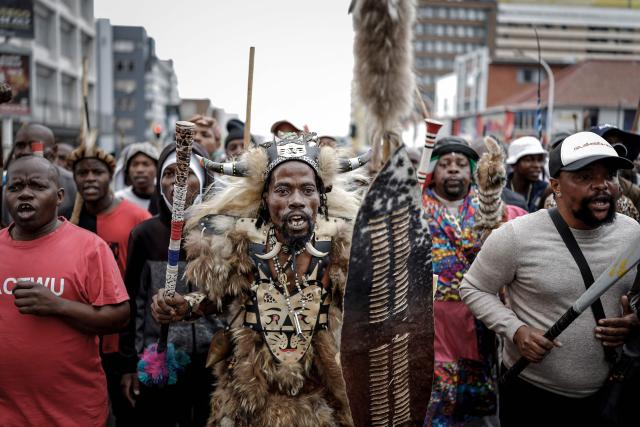 Members of the Zulu regiment known as the ‘Amabutho’ chant slogans as they march during a demonstration by the "March and March" movement marking an unofficial deadline set by citizen-led groups for undocumented foreign nationals to leave South Africa, in Durban, on June 30, 2026. South African police deployed to head off unrest and protests on June 30, 2026, the unofficial deadline set by anti-immigrant groups for undocumented foreign nationals to leave that has already pushed thousands to flee.
Officers were out in force to prevent violence and looting by the xenophobic groups, while hundreds of foreign nationals took refuge in several cities, urgently seeking help to leave. (Photo by Marco LONGARI / AFP)