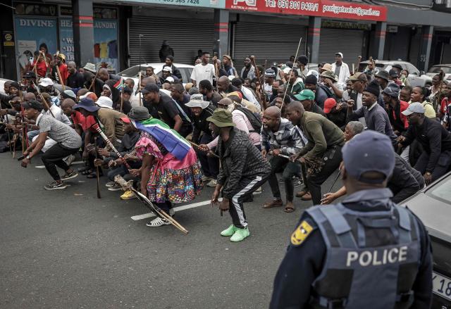 Protesters gesture and chant slogans during a demonstration by members of the "March and March" movement marking an unofficial deadline set by citizen-led groups for undocumented foreign nationals to leave South Africa, in Durban, on June 30, 2026. South African police deployed to head off unrest and protests on June 30, 2026, the unofficial deadline set by anti-immigrant groups for undocumented foreign nationals to leave that has already pushed thousands to flee.
Officers were out in force to prevent violence and looting by the xenophobic groups, while hundreds of foreign nationals took refuge in several cities, urgently seeking help to leave. (Photo by Rajesh JANTILAL / AFP)