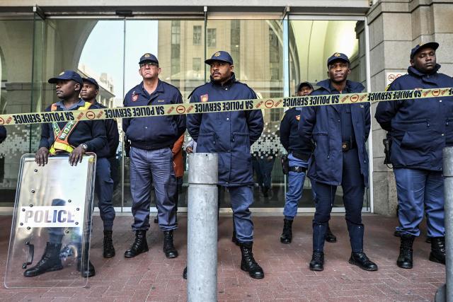 Members of the South African Police Service (SAPS) stand in formation as they monitor a demonstration by the "March and March" and Operation Dudula movements marking an unofficial deadline set by citizen-led groups for undocumented foreign nationals to leave South Africa, in Cape Town, on June 30, 2026. South African police deployed to head off unrest and protests on June 30, 2026, the unofficial deadline set by anti-immigrant groups for undocumented foreign nationals to leave that has already pushed thousands to flee.
Officers were out in force to prevent violence and looting by the xenophobic groups, while hundreds of foreign nationals took refuge in several cities, urgently seeking help to leave. (Photo by RODGER BOSCH / AFP)