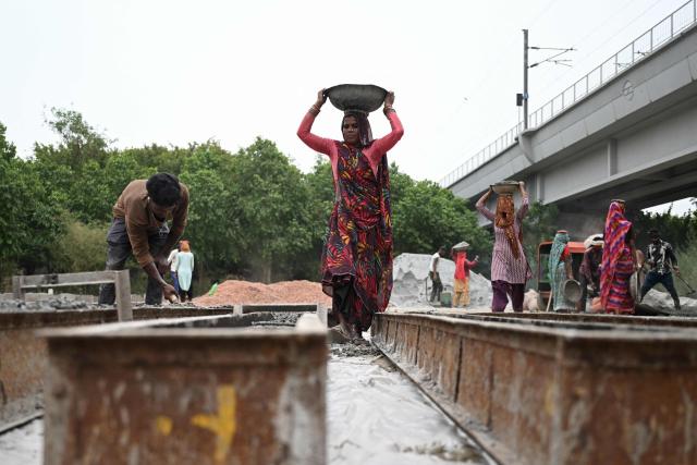 Workers make cement poles at a workshop in New Delhi on June 30, 2026. (Photo by Arun SANKAR / AFP)