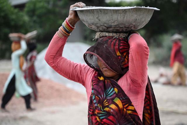 Workers make cement poles at a workshop in New Delhi on June 30, 2026. (Photo by Arun SANKAR / AFP)