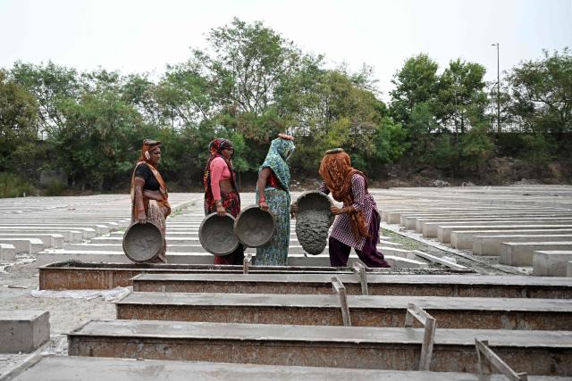 Workers make cement poles at a workshop in New Delhi on June 30, 2026. (Photo by Arun SANKAR / AFP)