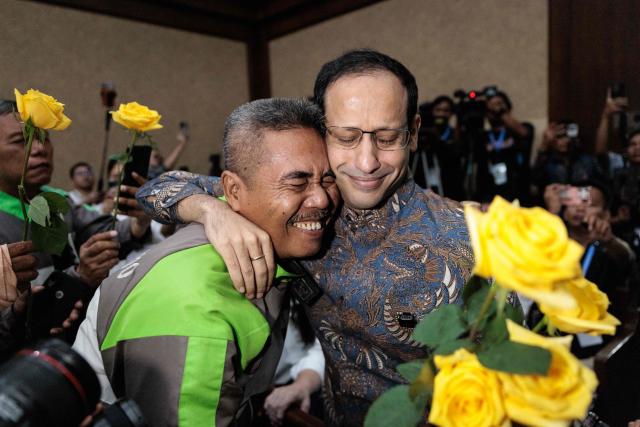 Nadiem Makarim (R), Indonesia's former education minister and co-founder of ride hailing company Gojek, reacts with a motorbike taxi driver as he arrives for a verdict hearing at the Central Jakarta District Court in Jakarta on June 30, 2026, in a corruption case related to the procurement of Chromebook laptops for schools during the Covid-19 pandemic. Judges found him guilty of corruption, sentencing him to 10 years in prison. The court also ordered Nadiem to pay a fine of 1 billion rupiah ($55,850) and 809 billion rupiah (more than $45 million) in restitution, or serve an additional prison term. (Photo by YASUYOSHI CHIBA / AFP)