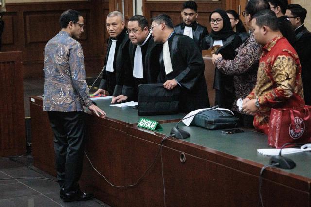 Nadiem Makarim (L), Indonesia's former education minister and co-founder of ride hailing company Gojek, speaks with lawyers after a verdict hearing at the Central Jakarta District Court in Jakarta on June 30, 2026, in a corruption case related to the procurement of Chromebook laptops for schools during the Covid-19 pandemic. Judges found him guilty of corruption, sentencing him to 10 years in prison. The court also ordered Nadiem to pay a fine of 1 billion rupiah ($55,850) and 809 billion rupiah (more than $45 million) in restitution, or serve an additional prison term. (Photo by YASUYOSHI CHIBA / AFP)