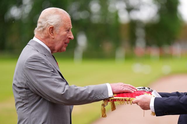 Lord Provost of Edinburgh Robert Aldridge (R) presents the keys to the city of Edinburgh to Britain's King Charles III (L) during the traditional "Ceremony of the Keys" in the Gardens of the Palace of Holyroodhouse in Edinburgh, Scotland on June 30, 2026, on the first day of the king and queen's visit to Scotland. (Photo by Aaron Chown / POOL / AFP)