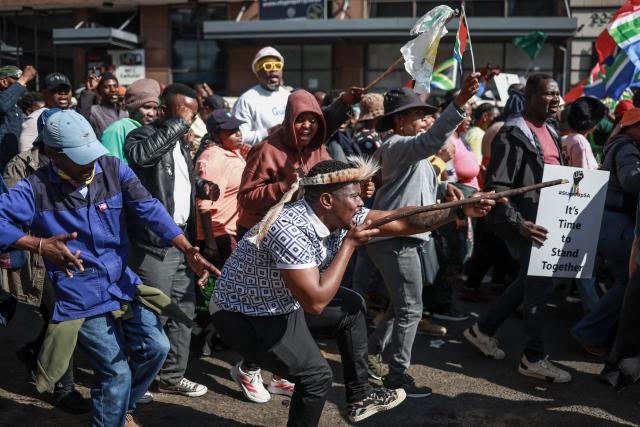 Protesters gesture and chant slogans as they march during a demonstration by the "March and March" and Operation Dudula movements marking an unofficial deadline set by citizen-led groups for undocumented foreign nationals to leave South Africa, in downtown Pretoria, on June 30, 2026. South African police deployed to head off unrest and protests on June 30, 2026, the unofficial deadline set by anti-immigrant groups for undocumented foreign nationals to leave that has already pushed thousands to flee.
Officers were out in force to prevent violence and looting by the xenophobic groups, while hundreds of foreign nationals took refuge in several cities, urgently seeking help to leave. (Photo by PHILL MAGAKOE / AFP)