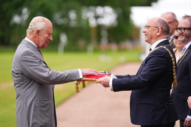 Lord Provost of Edinburgh Robert Aldridge (R) presents the keys to the city of Edinburgh to Britain's King Charles III (L) during the traditional "Ceremony of the Keys" in the Gardens of the Palace of Holyroodhouse in Edinburgh, Scotland on June 30, 2026, on the first day of the king and queen's visit to Scotland. (Photo by Aaron Chown / POOL / AFP)