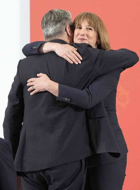 Britain's Prime Minister Keir Starmer is hugged by Britain's Chancellor of the Exchequer Rachel Reeves he delivers a speech in Berkshire west of London, on June 30, 2026, following the publication of long-delayed Defence Investment Plan (DIP). Outgoing Prime Minister Keir Starmer announced on June 30, his long-delayed plan for funding Britain's future defence needs, with increased money for drones and autonomous systems. (Photo by Stefan Rousseau / POOL / AFP)