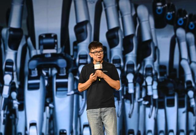 Zhou Jian, also known as James Zhou and founder of UBTECH Robotics delivers his speech during the launch of the U1 humanoid robot produced by UWORLD, a brand under UBTECH Robotics, in Shenzhen, China's Guangdong province on June 30, 2026. Silicone skin, soothing voice: Chinese company UBTech unveiled unprecedented hyper-realistic human-looking androids equipped with artificial intelligence (AI) and presented as anti-loneliness remedies. (Photo by ADEK BERRY / AFP)