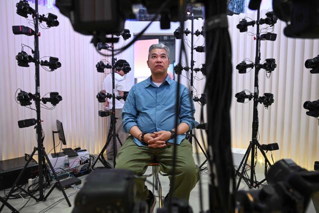 A man has his face scanned as part of a demonstration to create a customised humanoid robot during the launch of the U1 humanoid robot produced by UWORLD, a brand under UBTECH Robotics, in Shenzhen, China's Guangdong province on June 30, 2026. Silicone skin, soothing voice: Chinese company UBTech unveiled unprecedented hyper-realistic human-looking androids equipped with artificial intelligence (AI) and presented as anti-loneliness remedies. (Photo by ADEK BERRY / AFP)