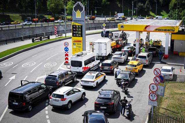 People queue to refuel their cars at a Rosneft gas station in Moscow on June 30, 2026. Russia's largest oil giants are tightening fuel restrictions at their gas stations in Moscow and the Moscow region as the fuel crisis, engulfed virtually every region, deepens after the Kapotnya refinery in Moscow burned twice in June as a result of Ukrainian drone strikes, as well as few more refineries in Russia, and now dispensing no more than 20 liters of gasoline per vehicle. Filling canisters is prohibited, local media report. (Photo by Alexander NEMENOV / AFP)