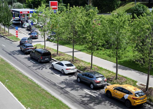 People queue to refuel their cars at a Teboil gas station in Moscow on June 30, 2026. Russia's largest oil giants are tightening fuel restrictions at their gas stations in Moscow and the Moscow region as the fuel crisis, engulfed virtually every region, deepens after the Kapotnya refinery in Moscow burned twice in June as a result of Ukrainian drone strikes, as well as few more refineries in Russia, and now dispensing no more than 20 liters of gasoline per vehicle. Filling canisters is prohibited, local media report. (Photo by Alexander NEMENOV / AFP)